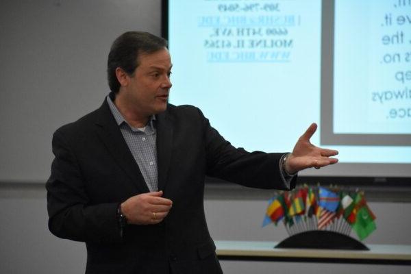 man in suit gesturing while speaking